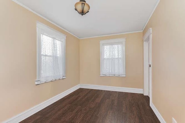 empty room featuring dark wood-type flooring, ornamental molding, and baseboards