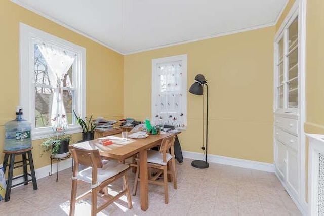 dining space featuring baseboards and crown molding