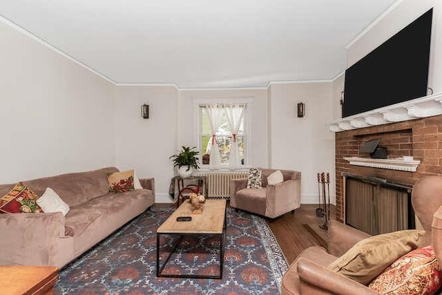 living room with radiator heating unit, a fireplace, dark wood finished floors, and crown molding