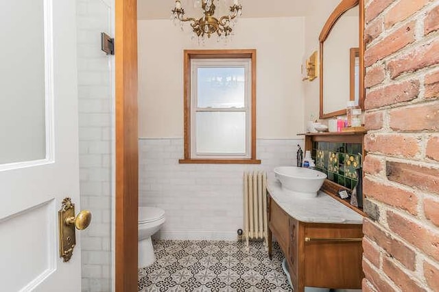 bathroom featuring toilet, radiator heating unit, wainscoting, vanity, and a chandelier