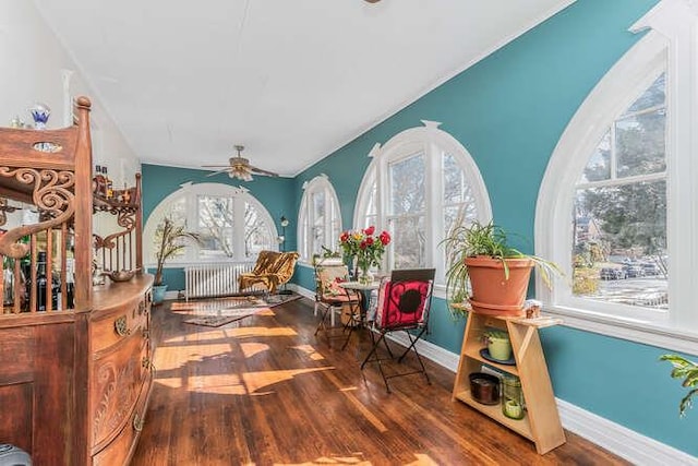 living area with ceiling fan, baseboards, and wood finished floors