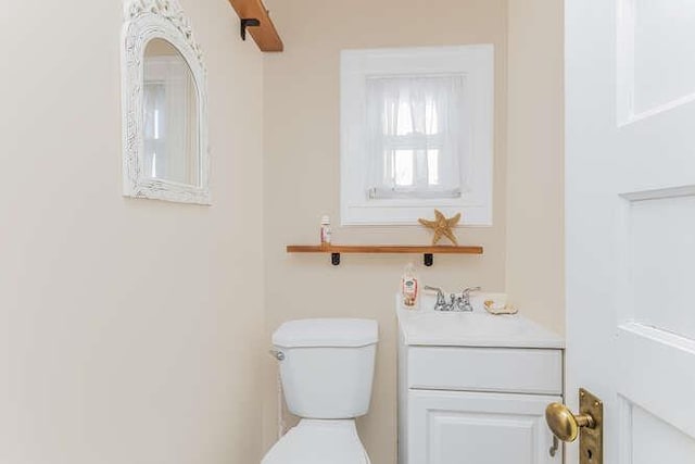 half bathroom with vanity and toilet