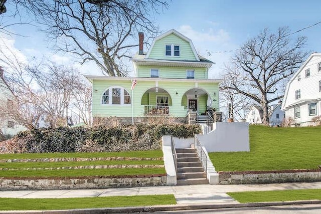 view of front of house featuring covered porch, a front lawn, stairs, and a gambrel roof