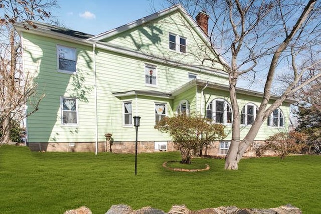 rear view of property with a yard and a chimney