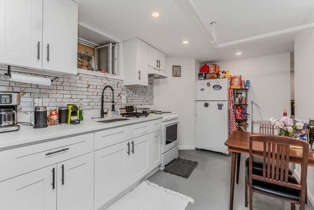 kitchen featuring white appliances, light countertops, a sink, and white cabinetry