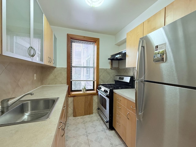 kitchen featuring decorative backsplash, appliances with stainless steel finishes, light countertops, under cabinet range hood, and a sink