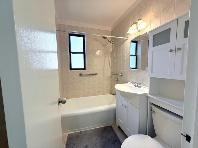 bathroom with toilet, vanity, tile patterned floors, shower / bathtub combination, and tile walls