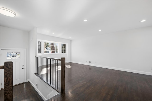 hallway featuring dark wood finished floors, recessed lighting, visible vents, an upstairs landing, and baseboards