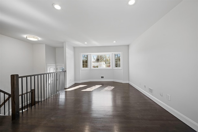 spare room with dark wood-style floors, recessed lighting, and baseboards