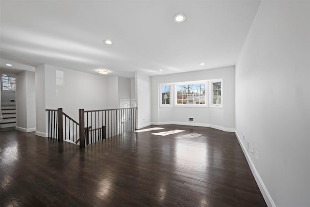 spare room featuring dark wood-style floors, baseboards, and recessed lighting