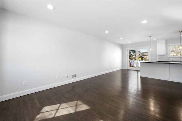 unfurnished living room with dark wood-style floors, recessed lighting, visible vents, and baseboards