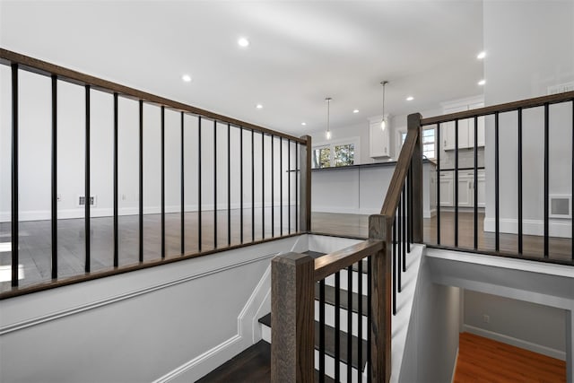 stairway with recessed lighting, visible vents, baseboards, and wood finished floors