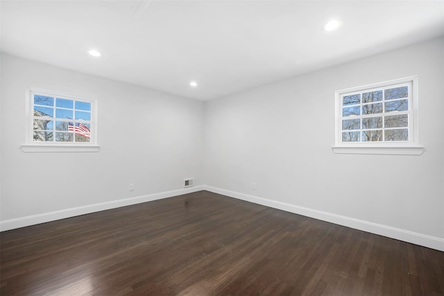 unfurnished room with dark wood-style floors, recessed lighting, visible vents, and baseboards