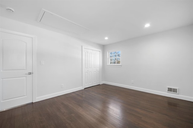 unfurnished bedroom featuring recessed lighting, visible vents, attic access, dark wood-type flooring, and baseboards