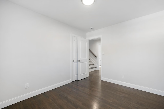 unfurnished room featuring dark wood-style floors and baseboards