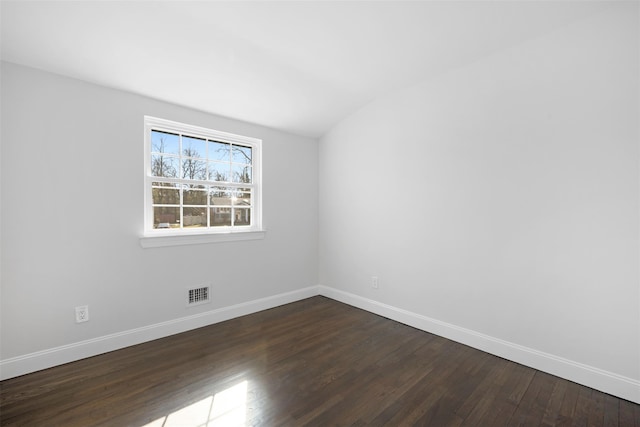 unfurnished room featuring baseboards, visible vents, and dark wood-type flooring