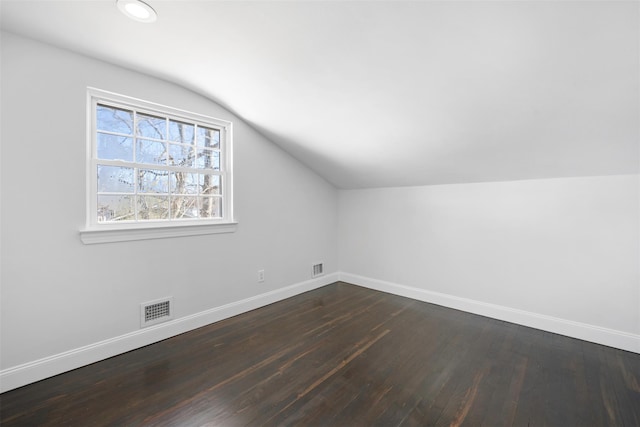 bonus room with dark wood-style flooring, visible vents, and baseboards