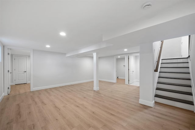 finished basement with light wood finished floors, stairs, and baseboards