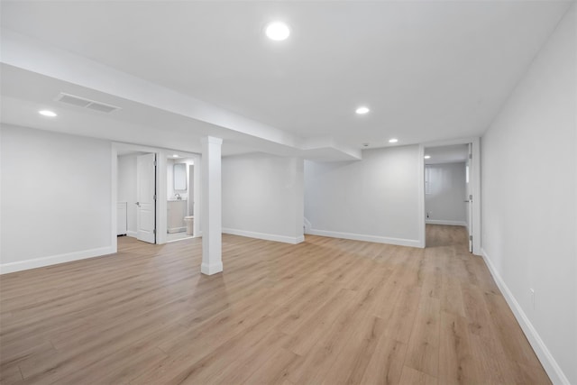 finished below grade area featuring light wood-type flooring, visible vents, baseboards, and recessed lighting