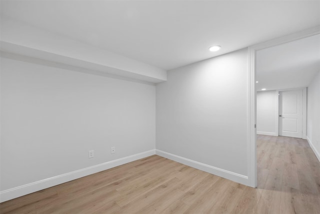 empty room with light wood-type flooring, baseboards, and recessed lighting