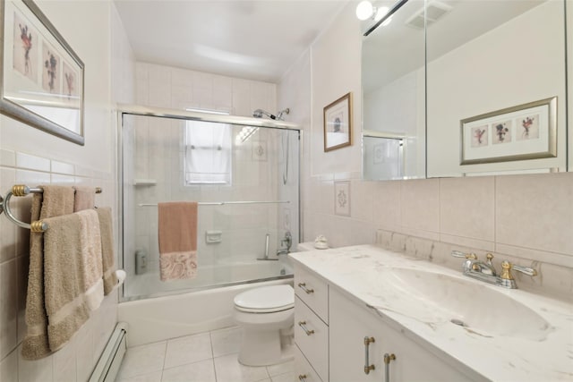 full bath with visible vents, vanity, baseboard heating, tile patterned floors, and tile walls