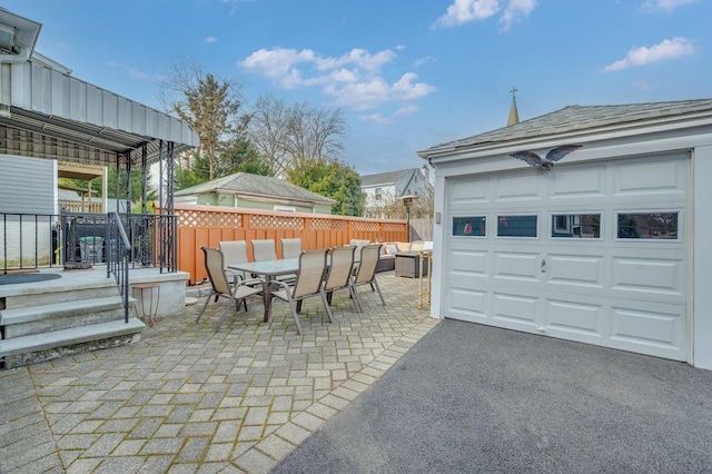 exterior space featuring a garage, outdoor dining space, and fence