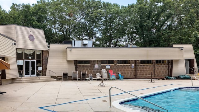 community pool with french doors and a patio area