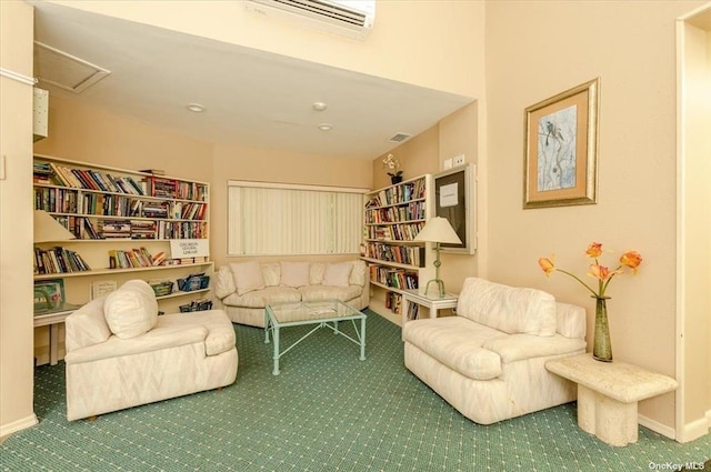 living area with carpet floors, attic access, a wall unit AC, and baseboards