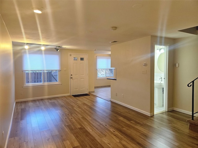 spare room featuring visible vents, stairs, baseboards, and wood finished floors