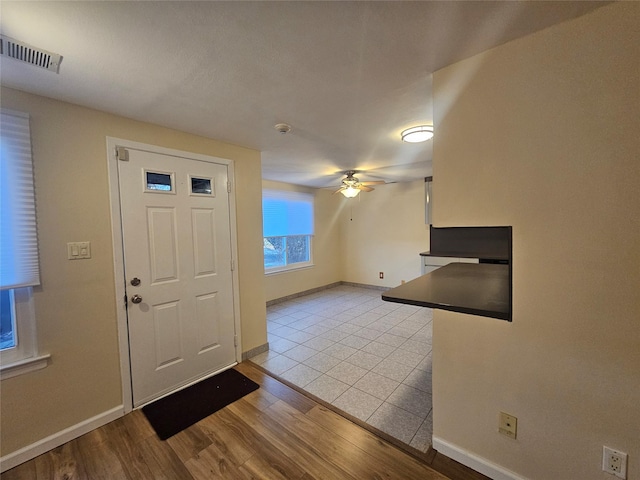 entrance foyer featuring visible vents, wood finished floors, a ceiling fan, and baseboards