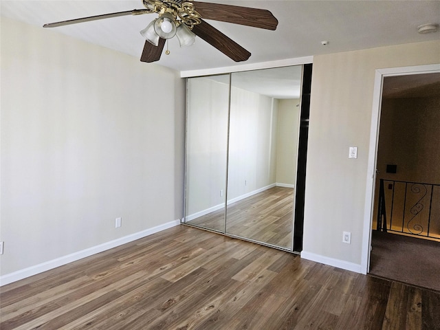 unfurnished bedroom with ceiling fan, a closet, baseboards, and wood finished floors