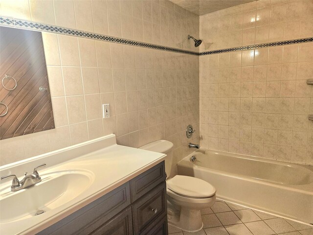 full bathroom featuring toilet, vanity, tile walls,  shower combination, and tile patterned floors