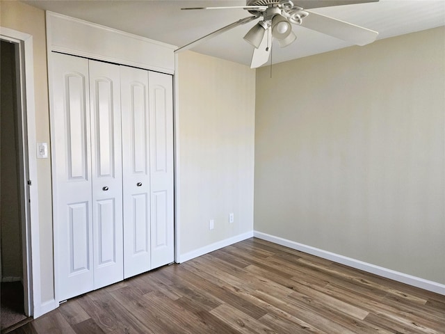 unfurnished bedroom featuring ceiling fan, a closet, baseboards, and wood finished floors