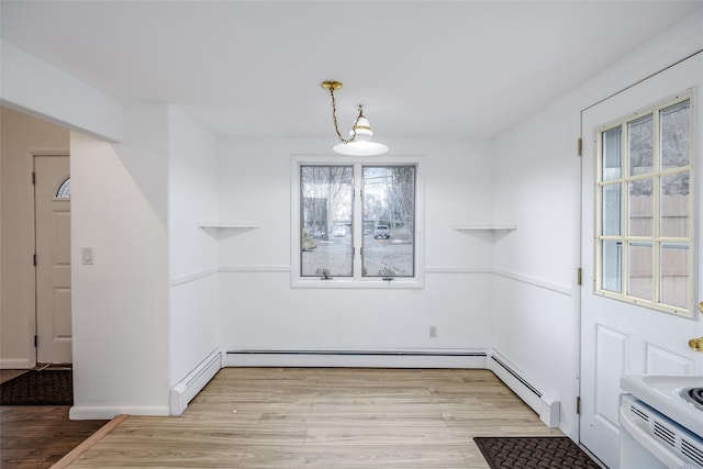 unfurnished dining area with light wood-style floors, a baseboard radiator, and a baseboard heating unit