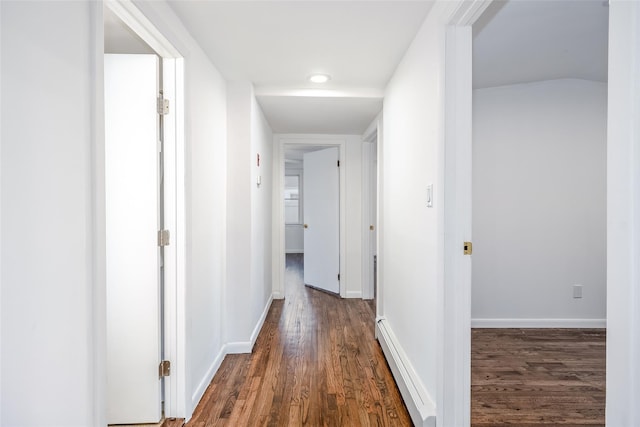 hall featuring dark wood-style floors, baseboards, and a baseboard heating unit