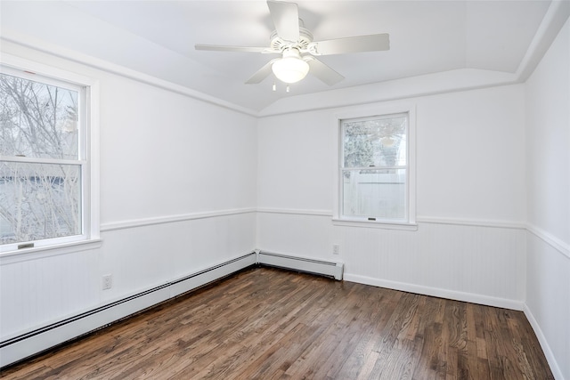 empty room with a baseboard radiator, vaulted ceiling, a healthy amount of sunlight, and dark wood finished floors