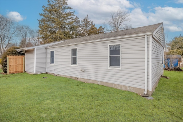 back of property featuring fence and a lawn