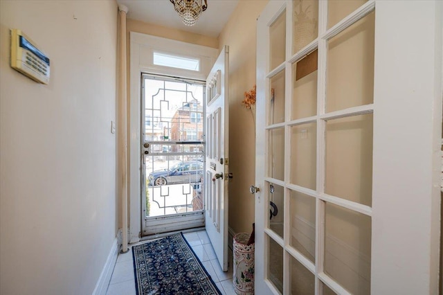 doorway to outside with baseboards and light tile patterned flooring