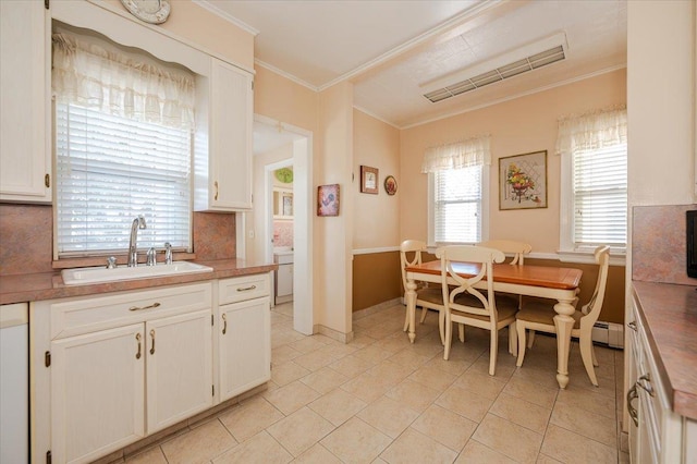 kitchen featuring crown molding, tasteful backsplash, a sink, and white cabinets