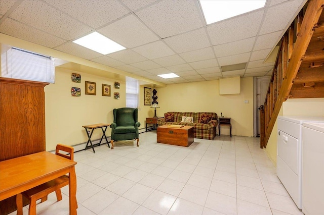 living room featuring a baseboard radiator, washer and clothes dryer, and a drop ceiling