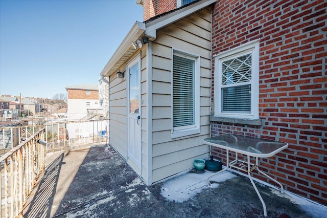 view of side of home featuring brick siding and fence