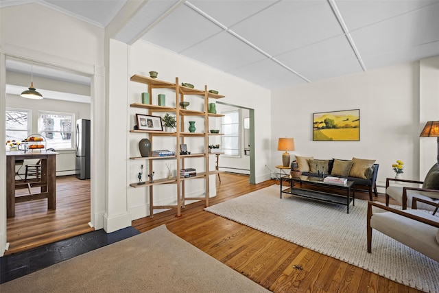 living area featuring a baseboard heating unit, a paneled ceiling, dark wood finished floors, and baseboards