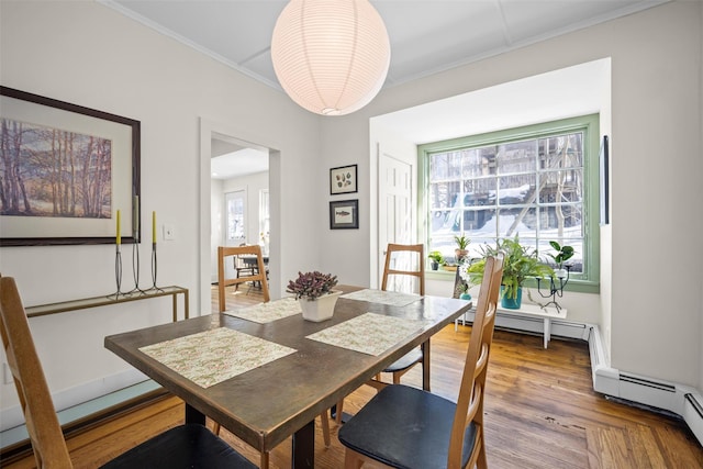 dining space with ornamental molding and wood finished floors