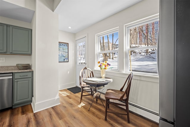 dining room with recessed lighting, baseboard heating, baseboards, and wood finished floors