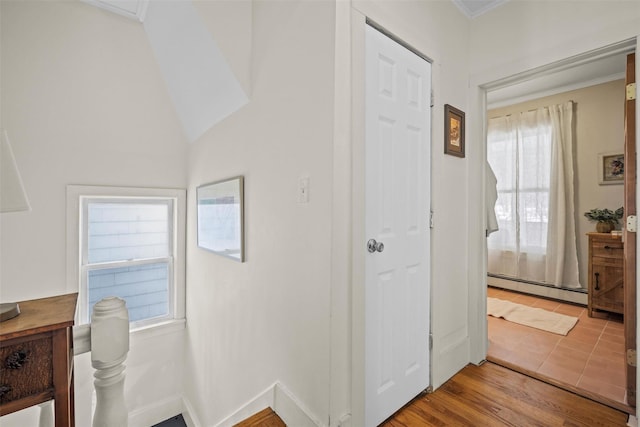 hallway with baseboard heating, wood finished floors, and baseboards