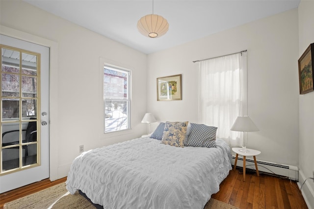 bedroom featuring a baseboard heating unit and wood finished floors