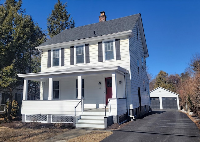 view of front of house featuring an outbuilding, a porch, a garage, a shingled roof, and a chimney