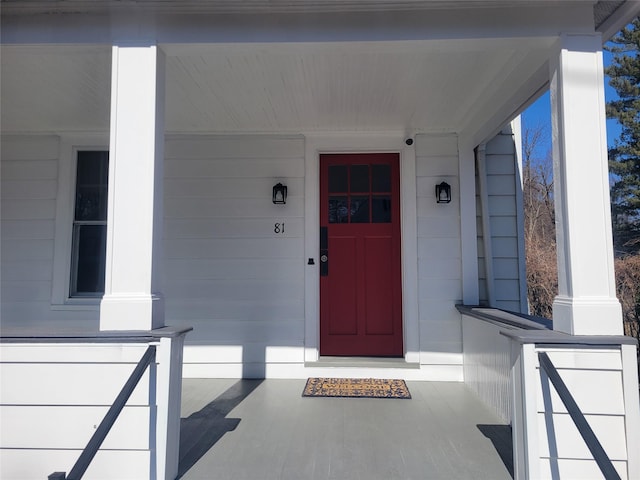 view of exterior entry featuring a porch and a garage