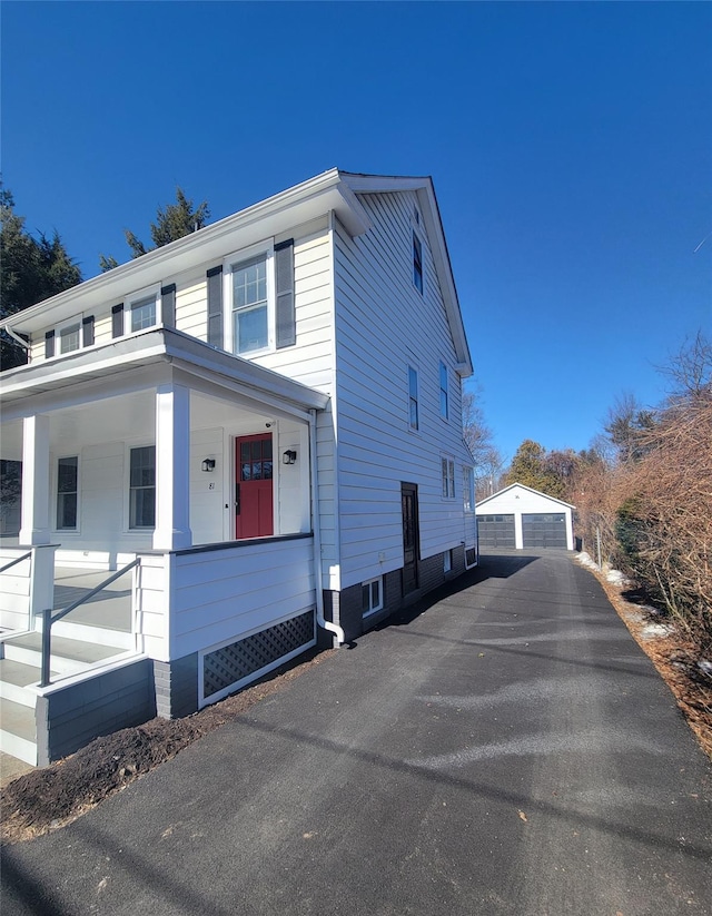 view of side of home with a porch, an outbuilding, and a garage