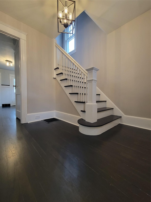 stairs featuring high vaulted ceiling, a notable chandelier, baseboards, and hardwood / wood-style flooring